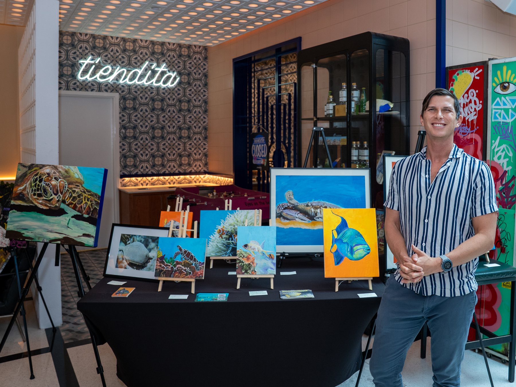 Patrick Louis presenting his paintings of South Florida sea life at a showcase